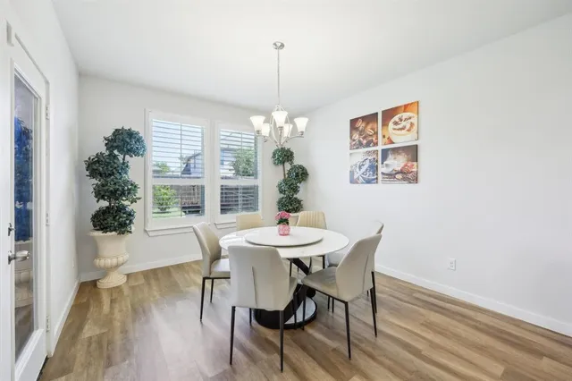a dining room with furniture a chandelier and wooden floor