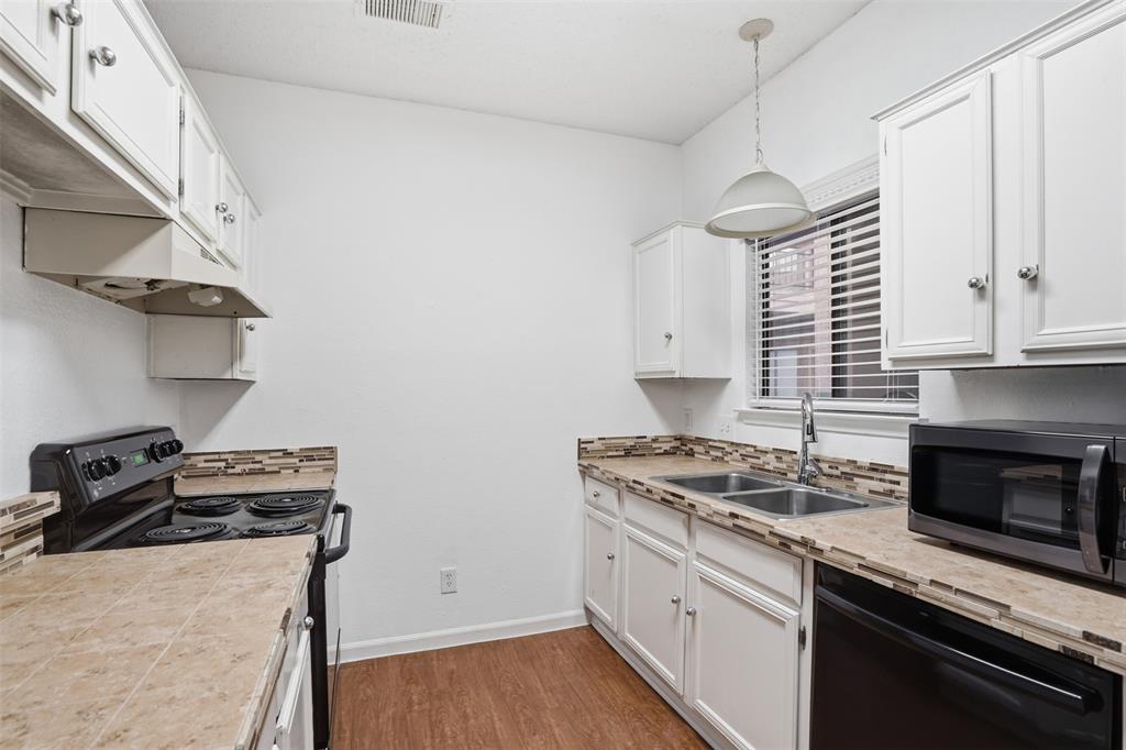 5550 Spring Valley Road, Unit F14 Dallas, TX 75254 - Photo 7 of 15 a kitchen with cabinets appliances and a wooden floor