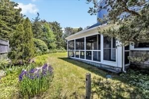 1 Carver Road Brewster, MA 02631 - Photo 4 of 33 a view of a house with a large window and wooden fence