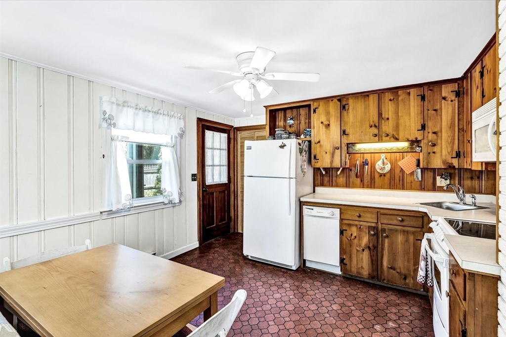1 Carver Road Brewster, MA 02631 - Photo 6 of 33 a kitchen with a refrigerator a sink and dishwasher with a dining table