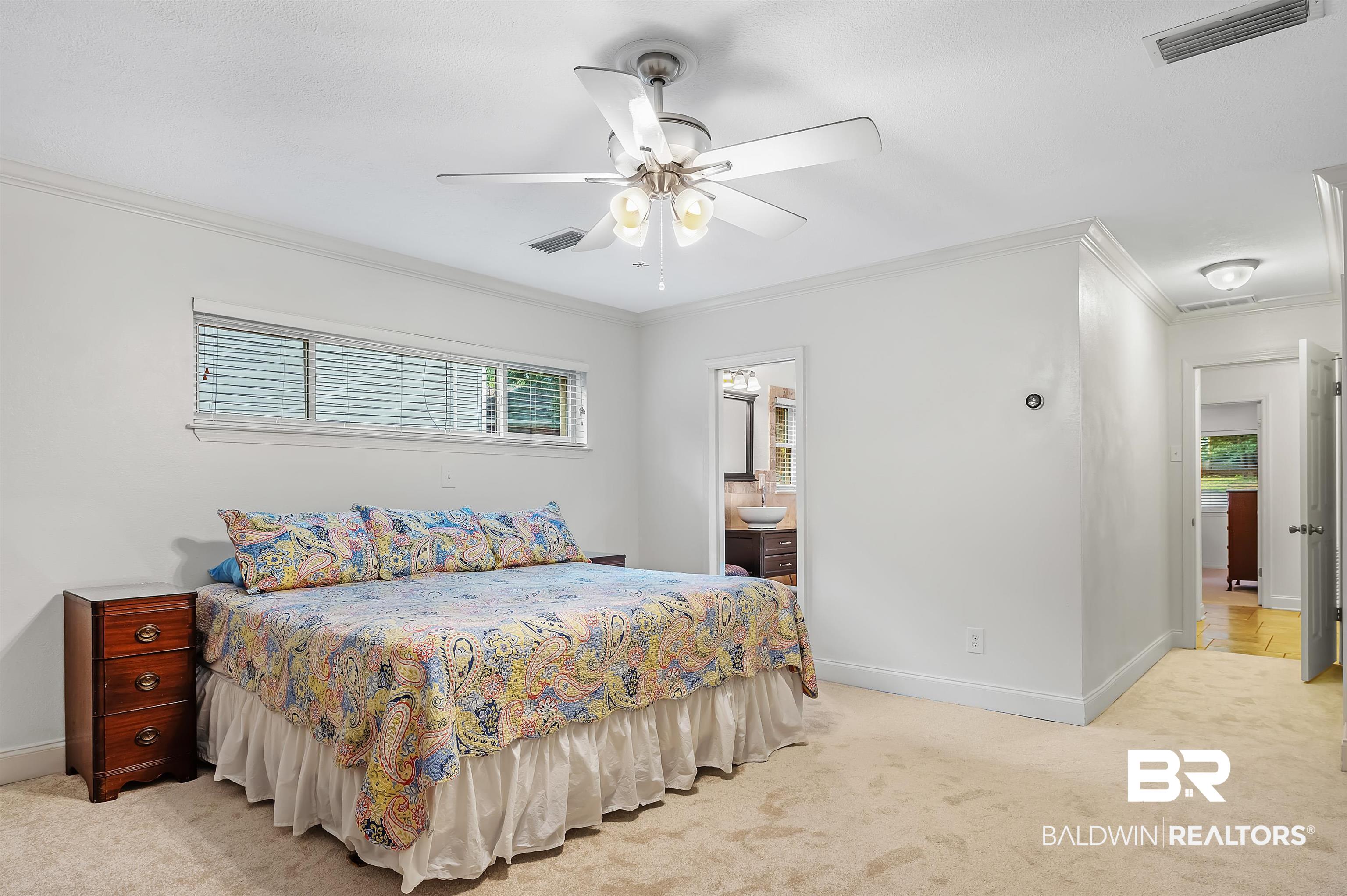 104 James Circle Daphne, AL 36526 - Photo 45 of 62 Bedroom with crown molding, ceiling fan, connected bathroom, and light colored carpet