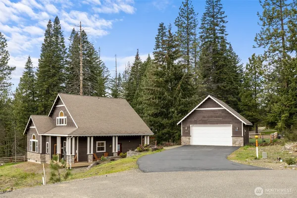 a front view of a house with a yard and trees