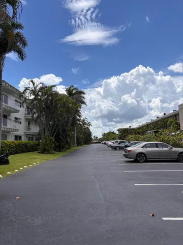 a picture of a building with a lot of plants and palm trees