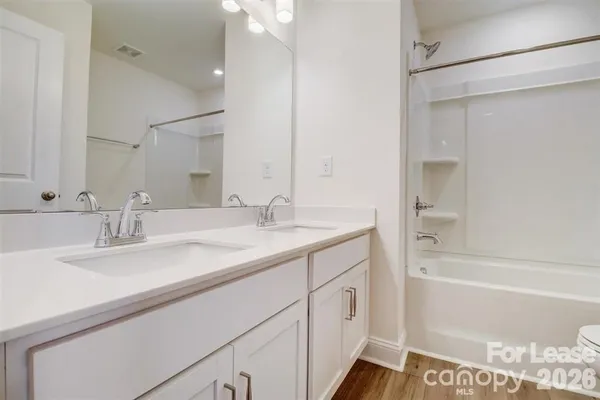 a bathroom with a sink double vanity granite tub shower and a mirror