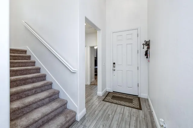 a view of a hallway with wooden floor and staircase