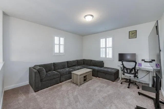 a spacious bedroom with a bed a dresser and flat screen tv