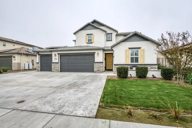 a front view of a house with a yard and garage
