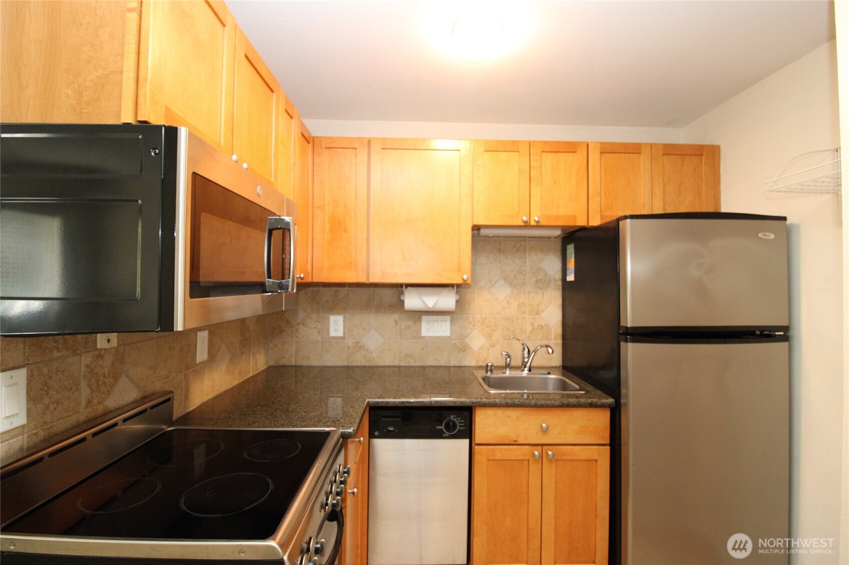 604 North 3rd Street, Unit 7 Tacoma, WA 98403 - Photo 7 of 12 a kitchen with granite countertop a refrigerator and a sink