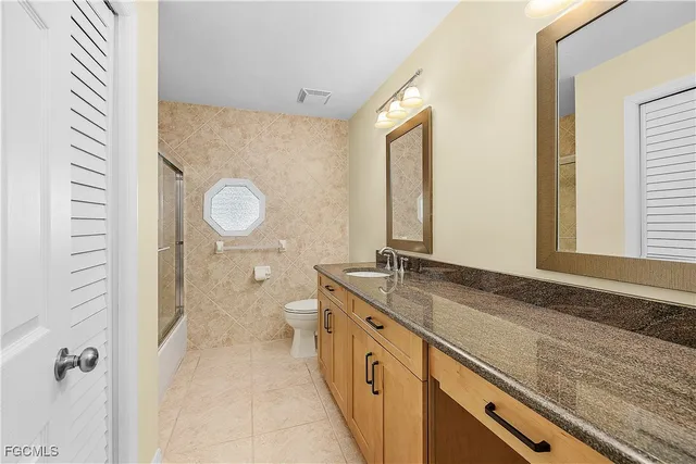 a spacious bathroom with a granite countertop sink and a mirror