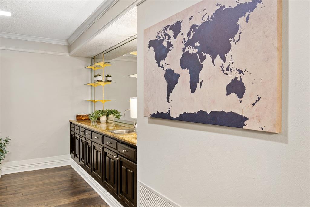 1105 East Spring Valley Road Richardson, TX 75081 - Photo 11 of 40 Bar with a textured ceiling, baseboards, ornamental molding, dark wood finished floors, and a sink