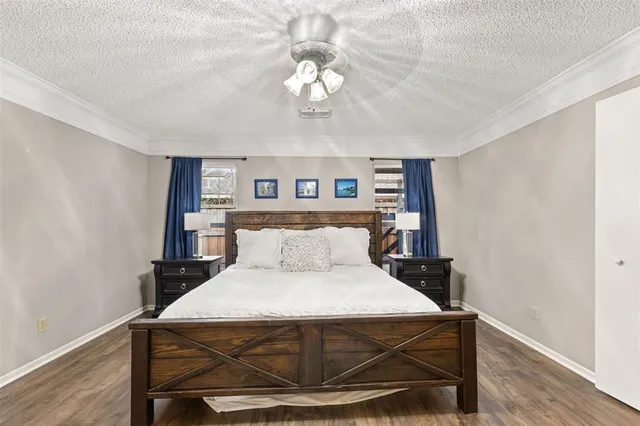 a bed sitting in a bedroom next to a window with a chandelier and table