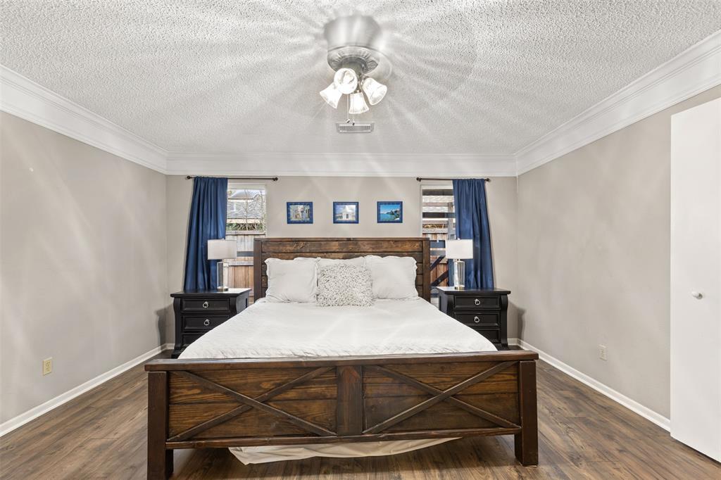 1105 East Spring Valley Road Richardson, TX 75081 - Photo 14 of 40 Bedroom featuring dark wood-type flooring, a textured ceiling, and baseboards