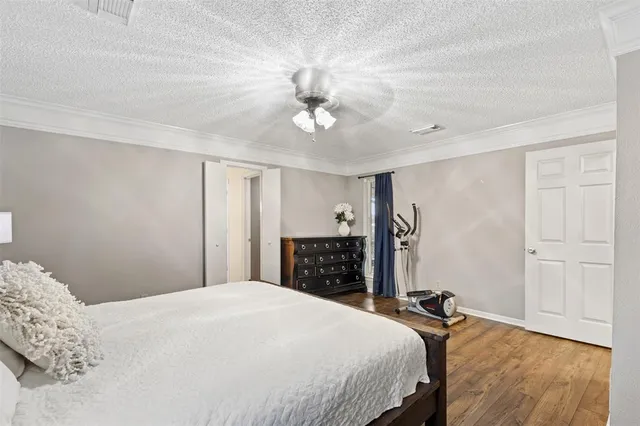 a bedroom with a bed chandelier and a window