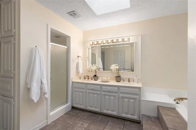 a bathroom with a double vanity sink mirror and shower