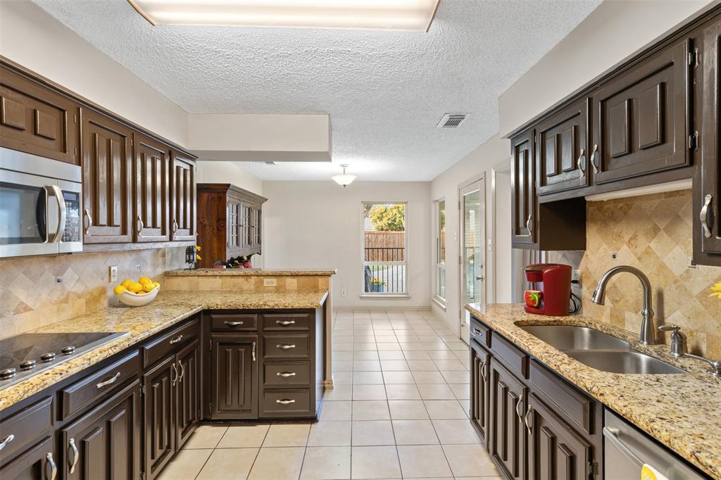 1105 East Spring Valley Road Richardson, TX 75081 - Photo 20 of 40 Kitchen with a sink, light tile patterned flooring, visible vents, a peninsula, and appliances with stainless steel finishes