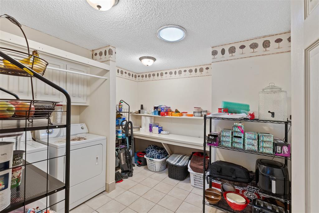 1105 East Spring Valley Road Richardson, TX 75081 - Photo 28 of 40 Laundry area with light tile patterned floors, a textured ceiling, laundry area, and washer and clothes dryer