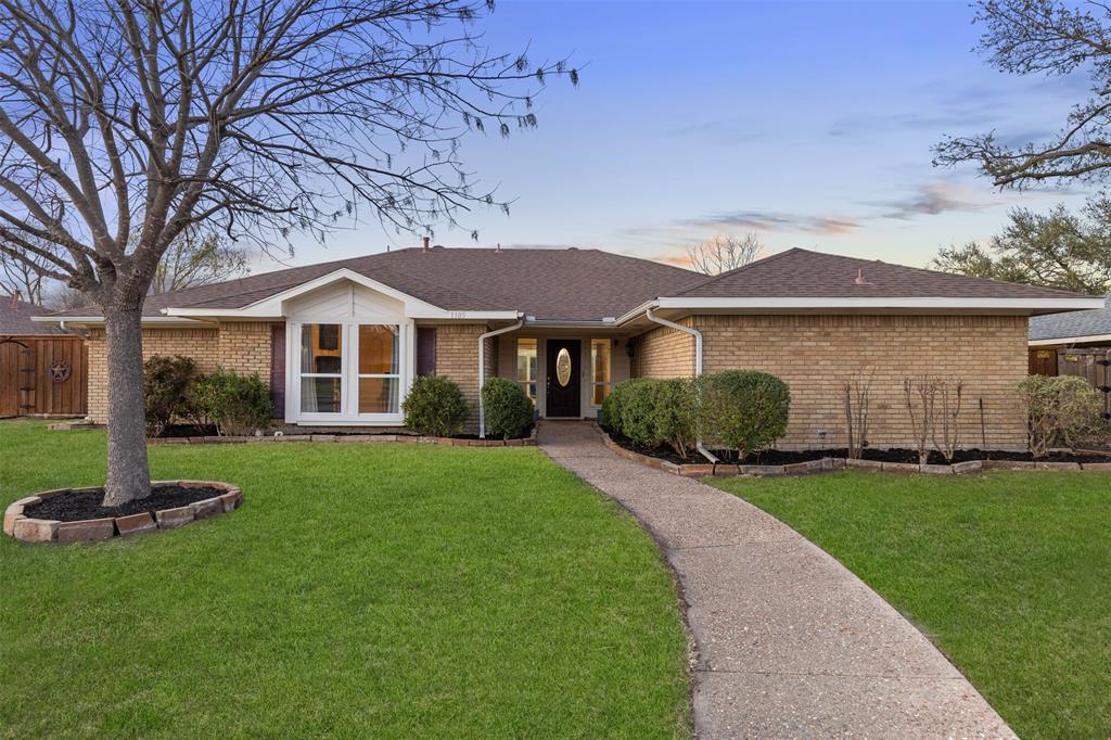 1105 East Spring Valley Road Richardson, TX 75081 - Photo 35 of 40 View of front of house featuring roof with shingles, brick siding, fence, and a yard