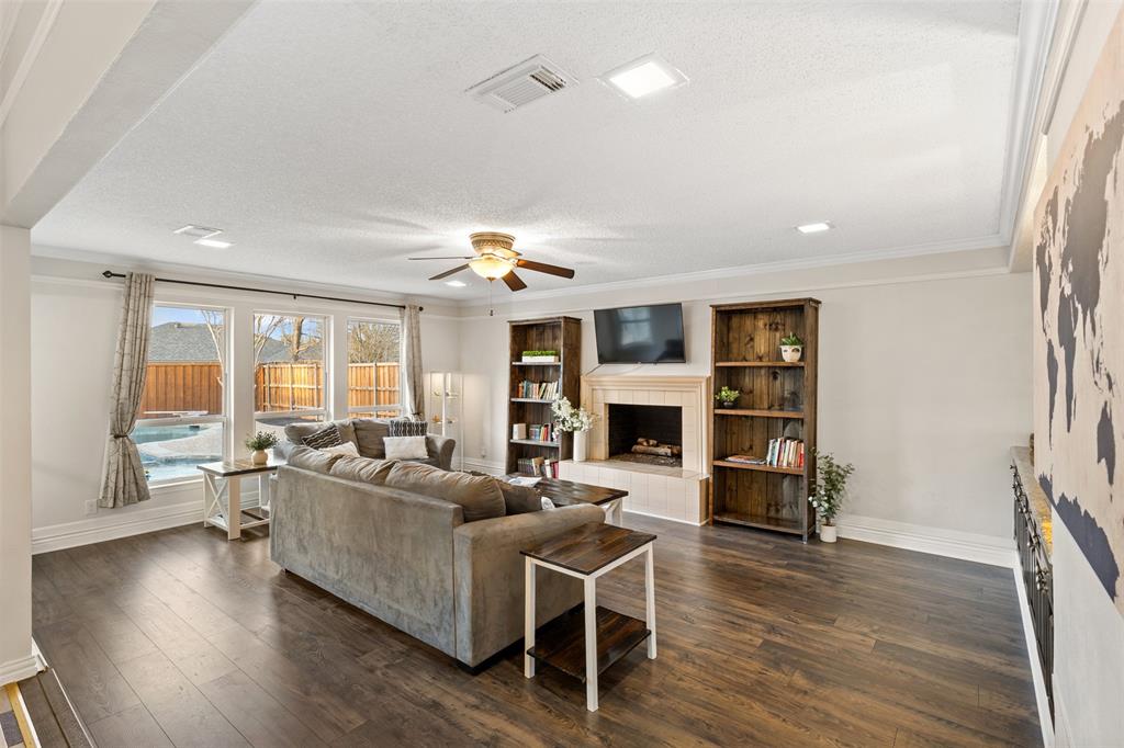 1105 East Spring Valley Road Richardson, TX 75081 - Photo 5 of 40 Living area with a ceiling fan, dark wood-style floors, a fireplace, and visible vents