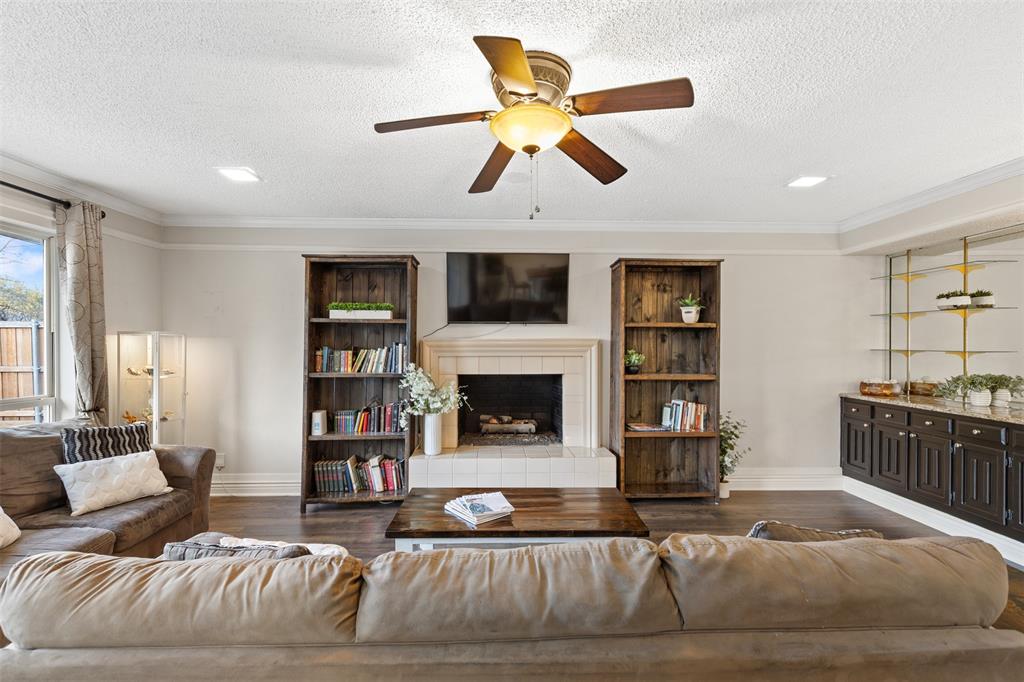 1105 East Spring Valley Road Richardson, TX 75081 - Photo 6 of 40 Living area with a textured ceiling, dark wood-style flooring, a ceiling fan, and crown molding