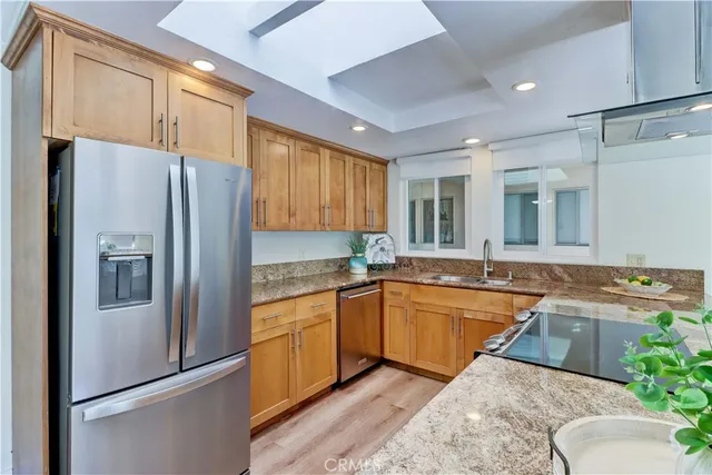 a kitchen with stainless steel appliances granite countertop a sink a stove and a refrigerator