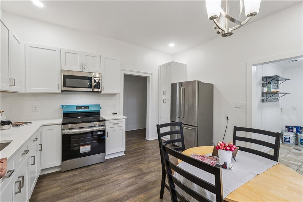 1820 Cassville Road Northwest Cartersville, GA 30121 - Photo 10 of 24 a kitchen with stainless steel appliances kitchen island granite countertop a refrigerator a stove a microwave oven a sink with island and chairs