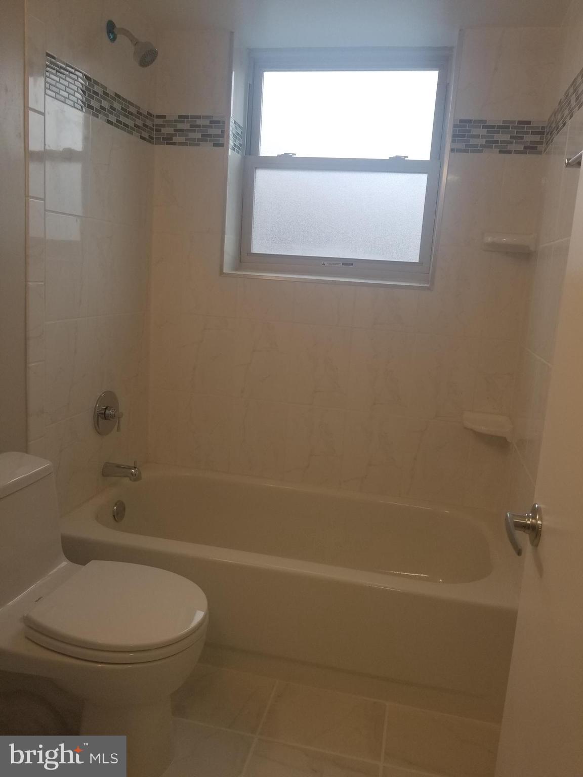 2647 Martin Luther King Jr Avenue Southeast, Unit 203 Washington, DC 20020 - Photo 15 of 28 a bathroom with a toilet and a bath tub