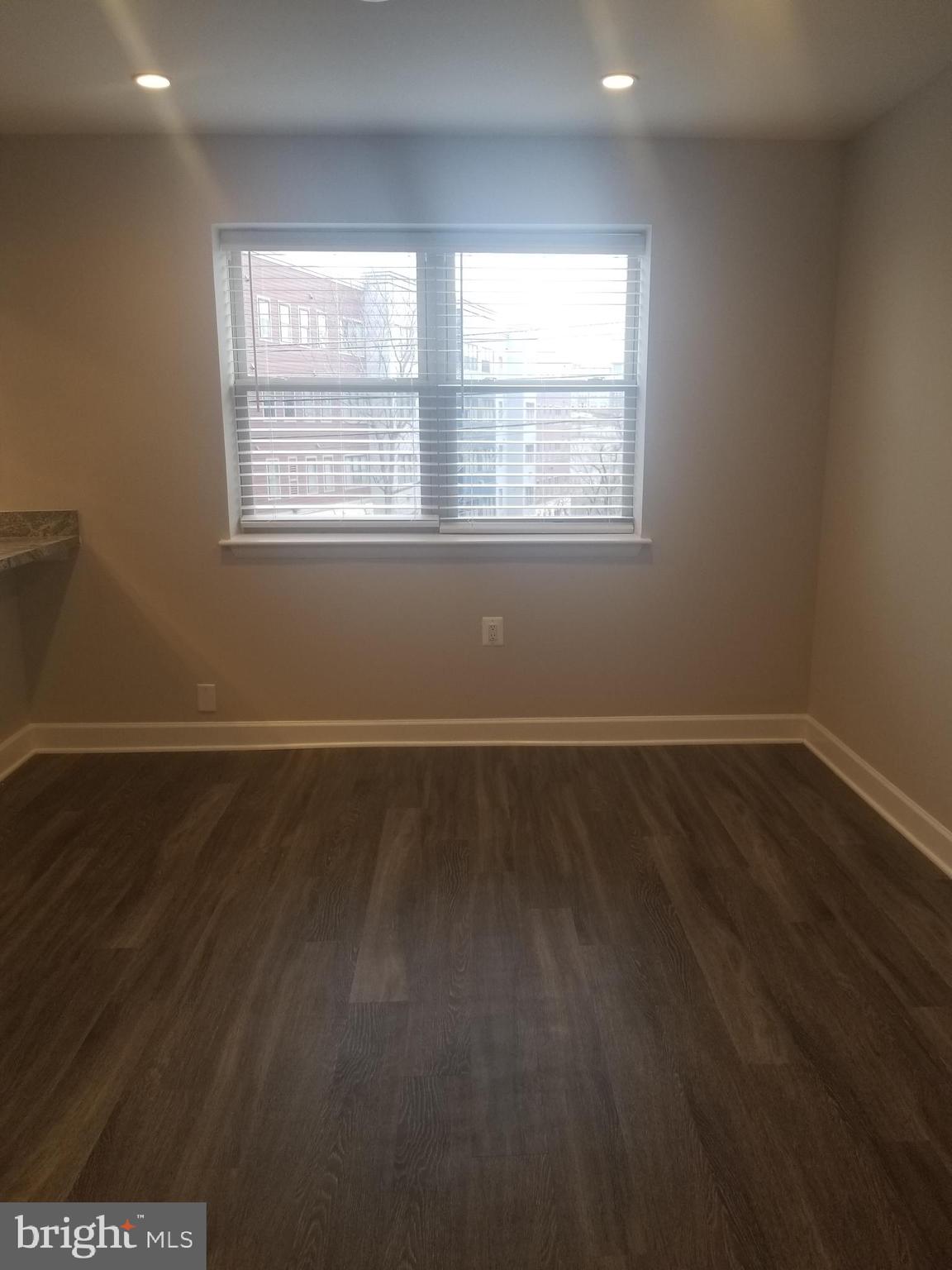 2647 Martin Luther King Jr Avenue Southeast, Unit 203 Washington, DC 20020 - Photo 3 of 28 an empty room with wooden floor and windows