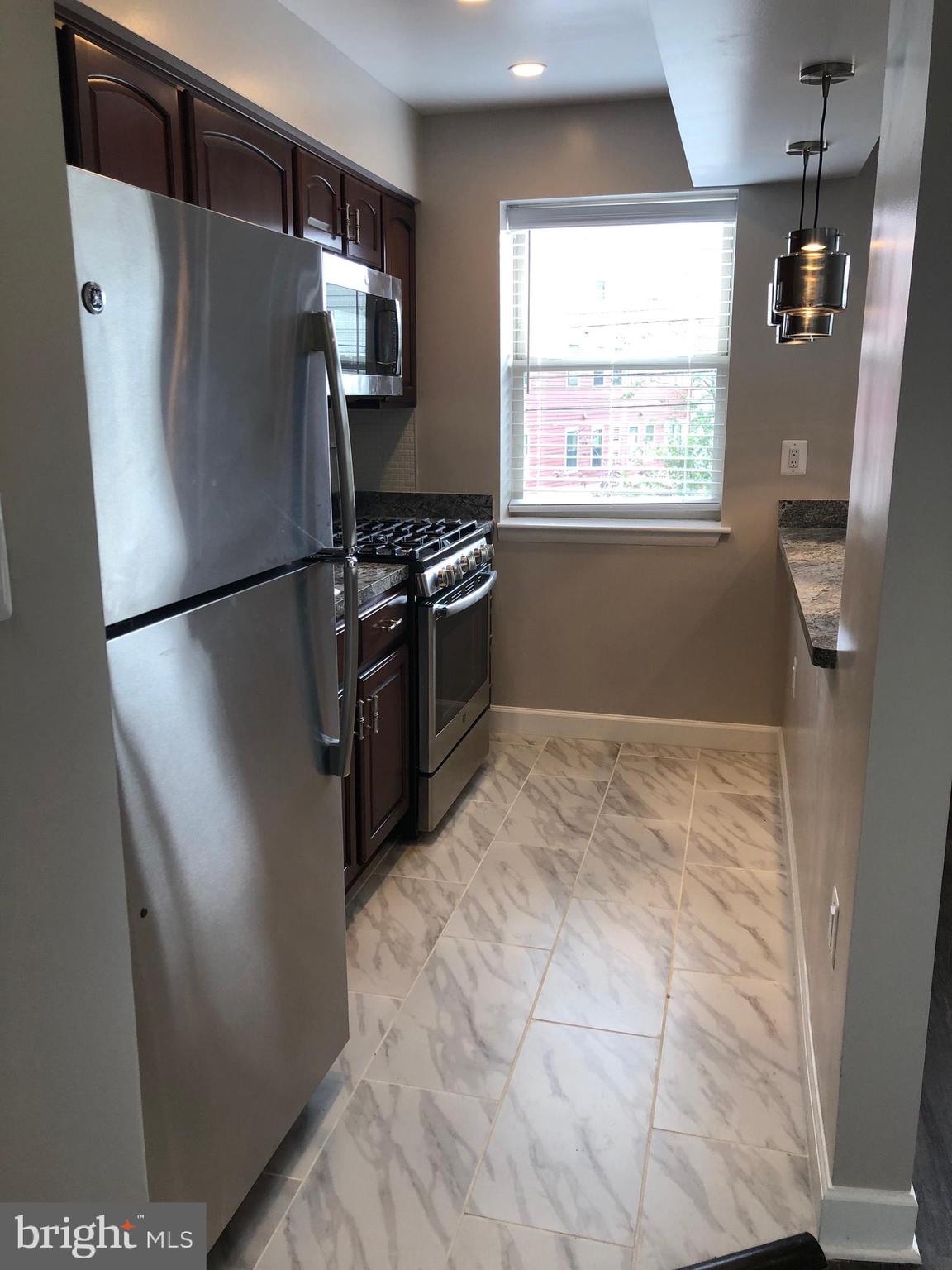 2647 Martin Luther King Jr Avenue Southeast, Unit 203 Washington, DC 20020 - Photo 8 of 28 a white refrigerator freezer sitting inside of a kitchen