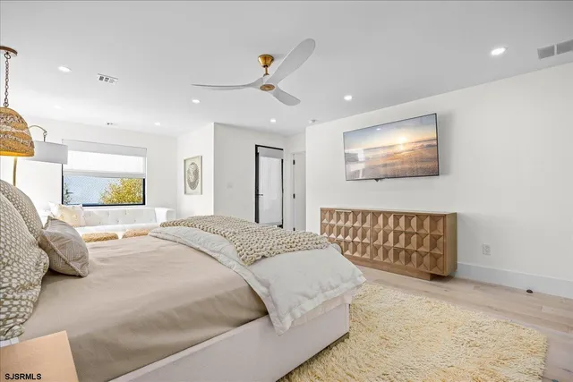 a bedroom with a large bed and a chandelier