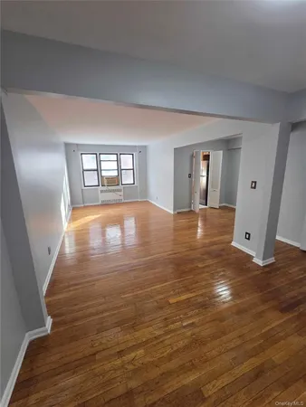 a view of a room with wooden floor and white walls