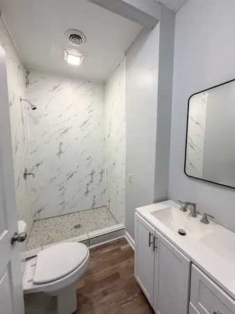 a bathroom with a sink a toilet and shower