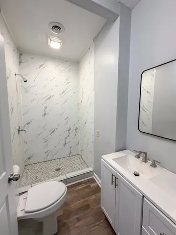 a bathroom with a sink a toilet and shower