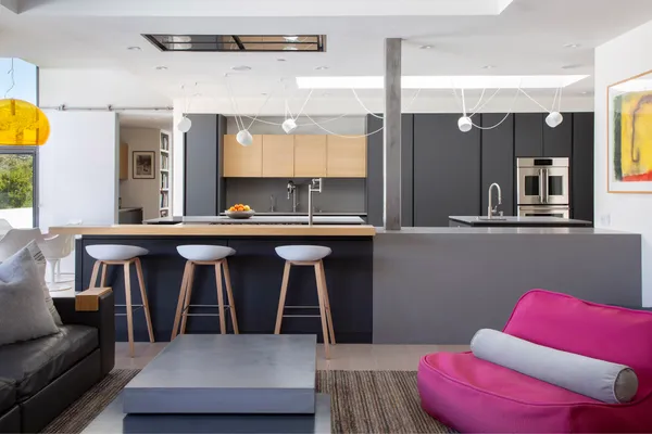 a living room with stainless steel appliances kitchen island granite countertop furniture and a large window