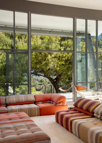 a bedroom with furniture and large windows