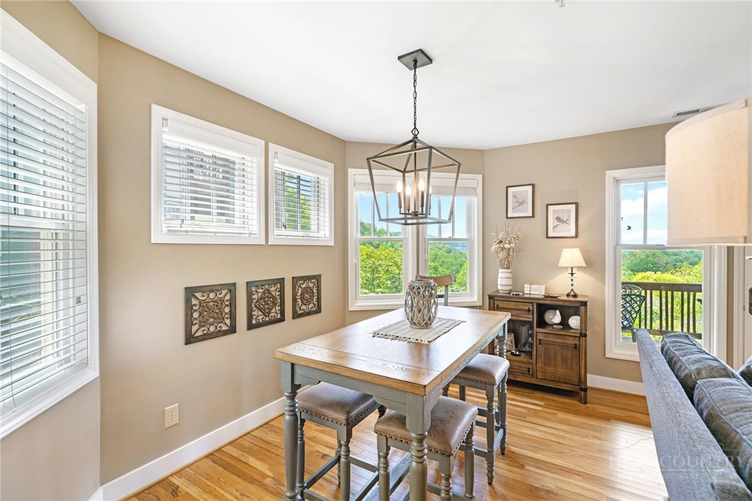 942 Ridge Haven Parkway, Unit R1211 Banner Elk, NC 28604 - Photo 11 of 45 a view of a dining room with furniture window and wooden floor