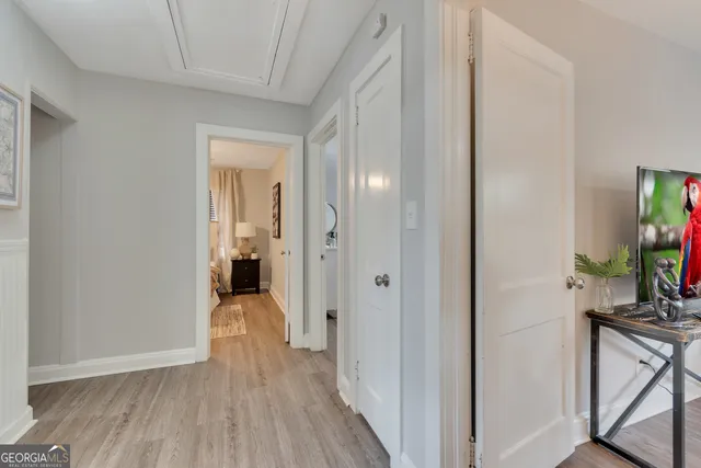 a view of a hallway with wooden floor and furniture