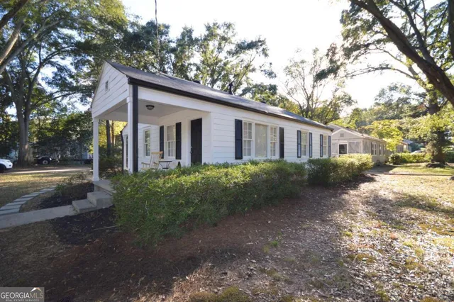 a view of a house with backyard and trees