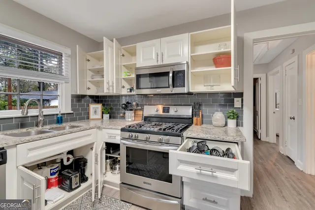 a kitchen with stainless steel appliances granite countertop a stove and a microwave