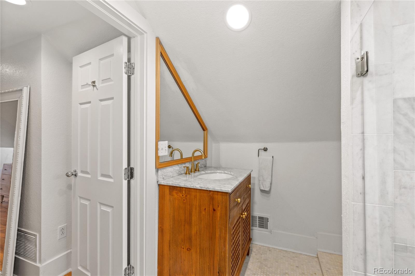 2740 Fillmore Street Denver, CO 80205 - Photo 29 of 45 a bathroom with a sink and mirror