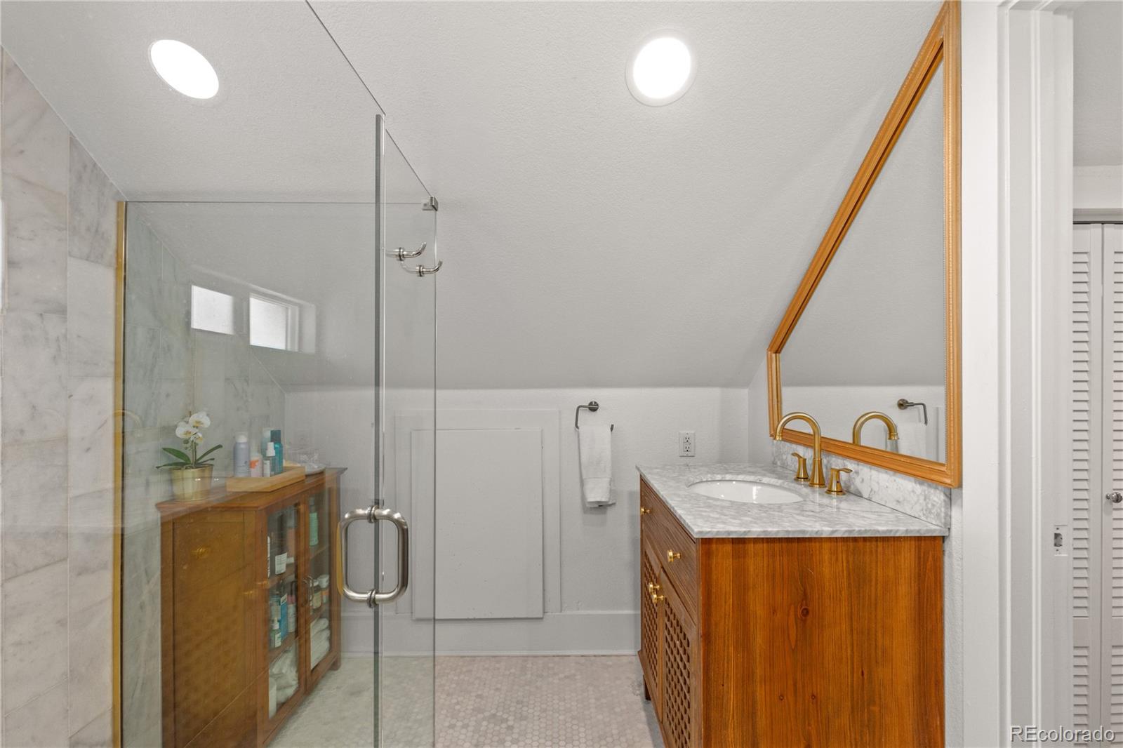 2740 Fillmore Street Denver, CO 80205 - Photo 31 of 45 a bathroom with a granite countertop sink and a mirror