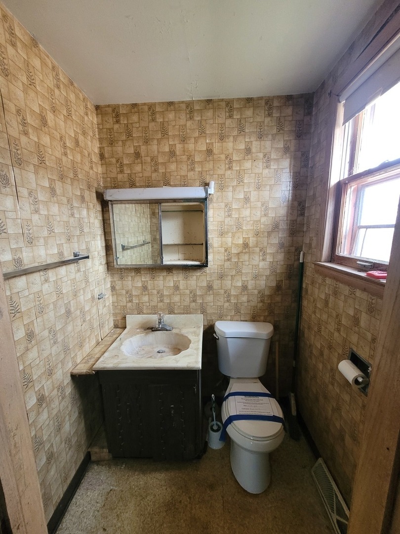 14340 Kostner Avenue Midlothian, IL 60445 - Photo 9 of 15 a bathroom with a toilet sink and mirror