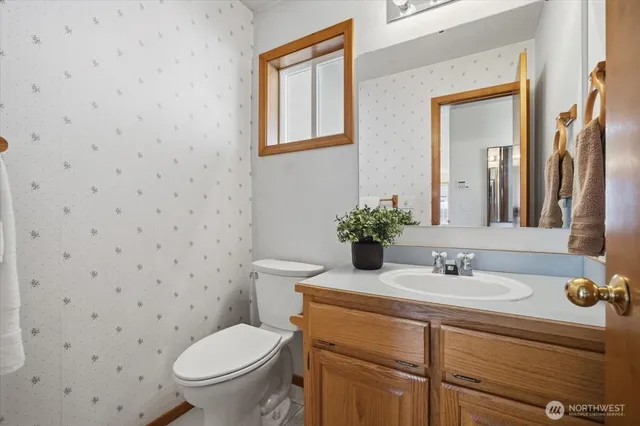 a bathroom with a granite countertop toilet sink and mirror