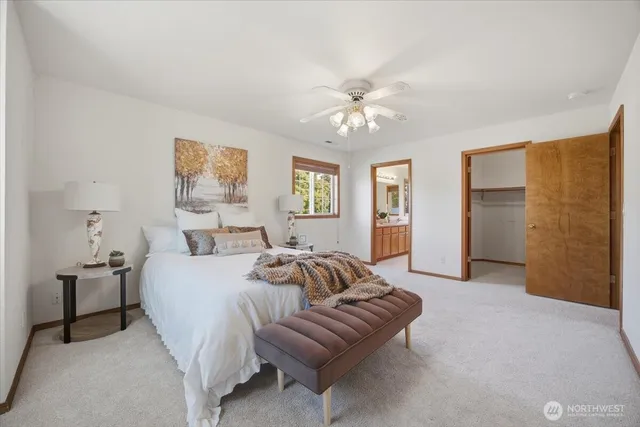 a spacious bedroom with a bed and ceiling fan