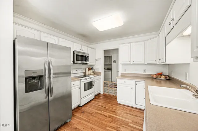 a kitchen with white cabinets and stainless steel appliances