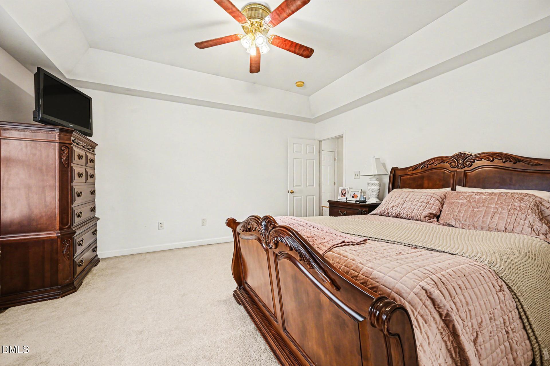 2070 Haw River Hopedale Road Burlington, NC 27217 - Photo 12 of 30 a bedroom with a bed and a chandelier