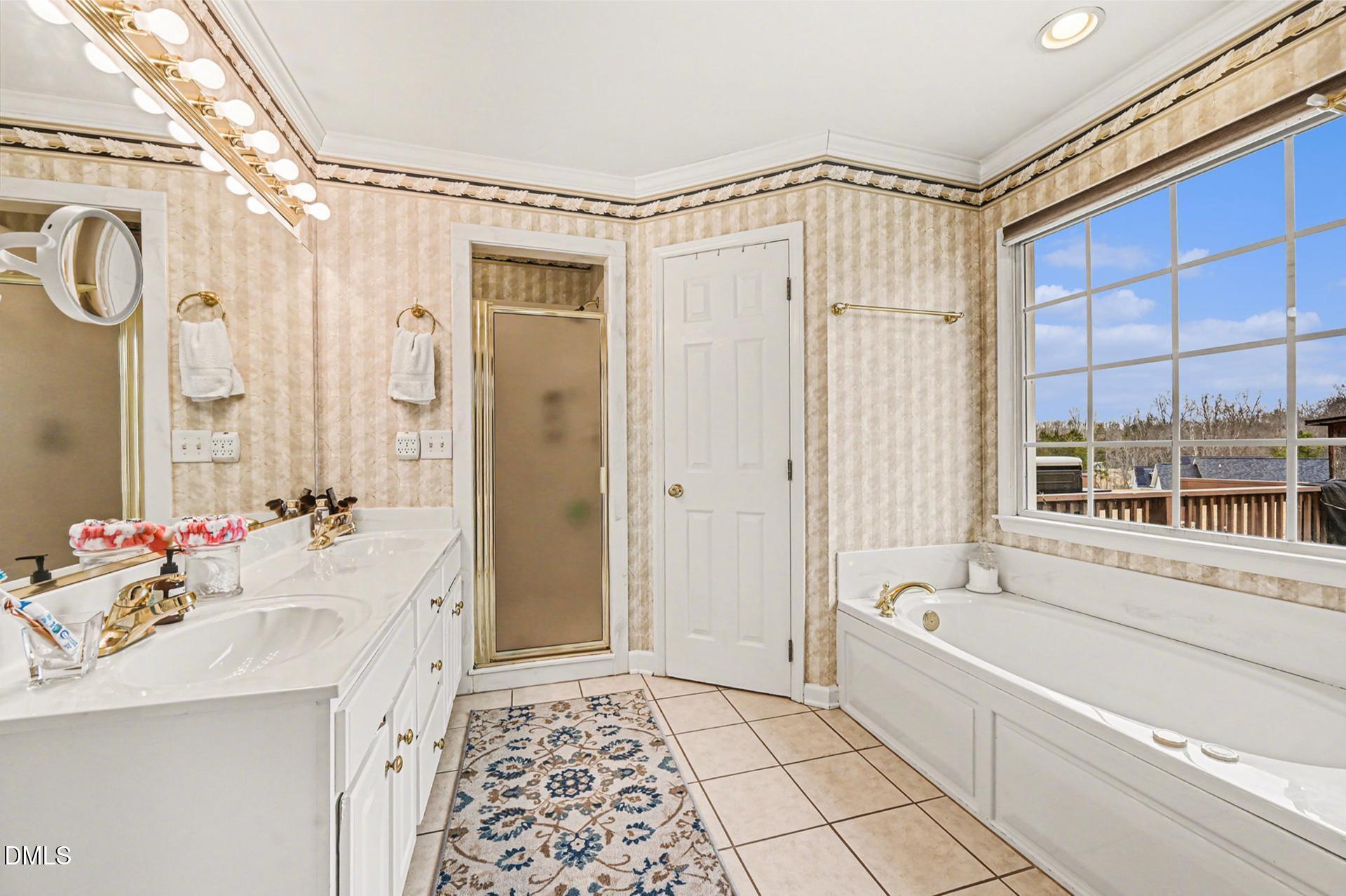 2070 Haw River Hopedale Road Burlington, NC 27217 - Photo 15 of 30 a bathroom with a sink a mirror a bathtub and shower