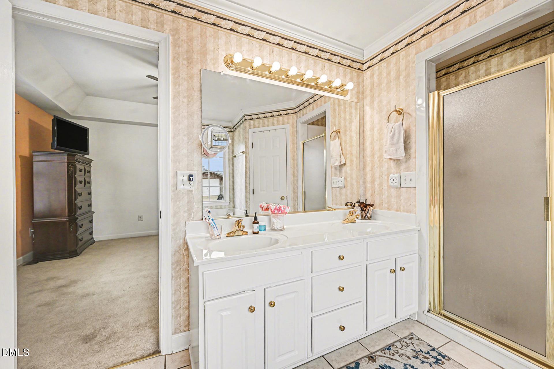 2070 Haw River Hopedale Road Burlington, NC 27217 - Photo 16 of 30 a spacious bathroom with a double vanity sink a large mirror a shower and a bathtub