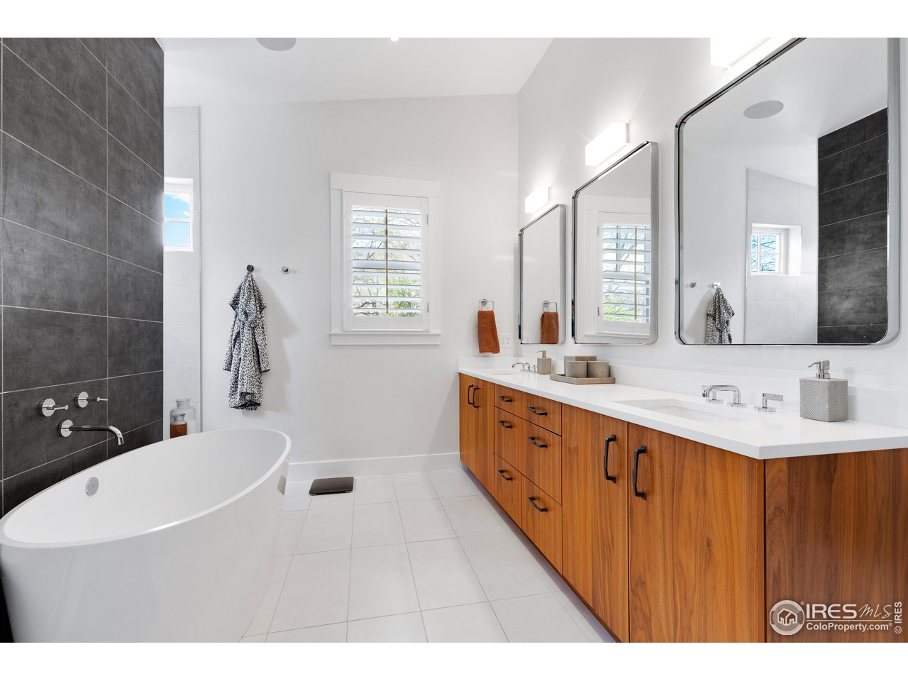 3191 9th Street Boulder, CO 80304 - Photo 22 of 40 a bathroom with a double vanity sink a toilet a mirror and shower