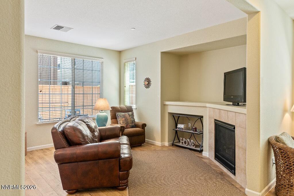 1864 Wind Ranch Road, Unit B Reno, NV 89521 - Photo 10 of 42 a living room with furniture a flat screen tv and a fireplace