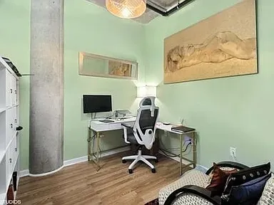 a view of a workspace with furniture and wooden floor